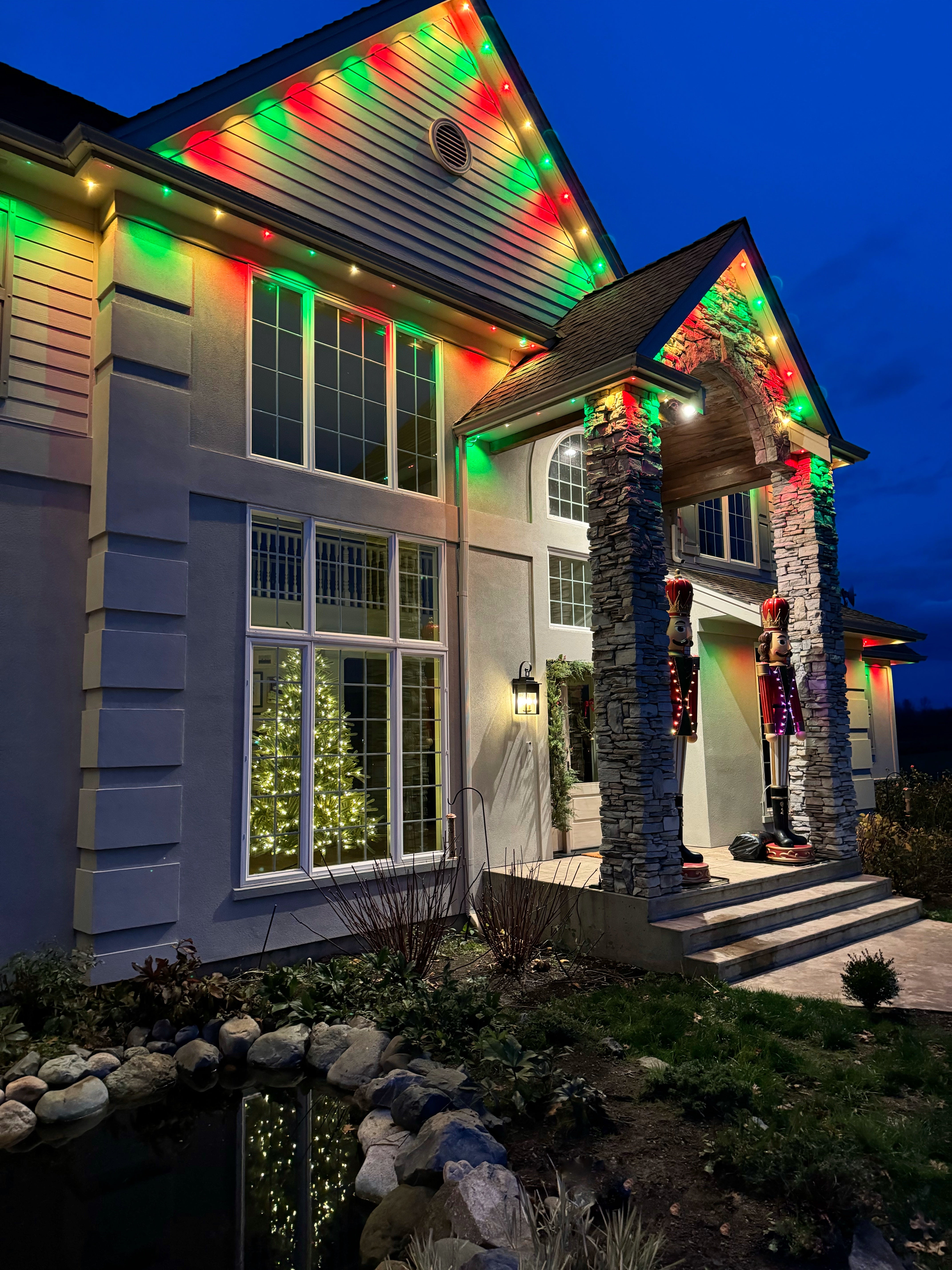 House exterior with colorful enbrighten eave lights on the roof and porch area in christmas color mode